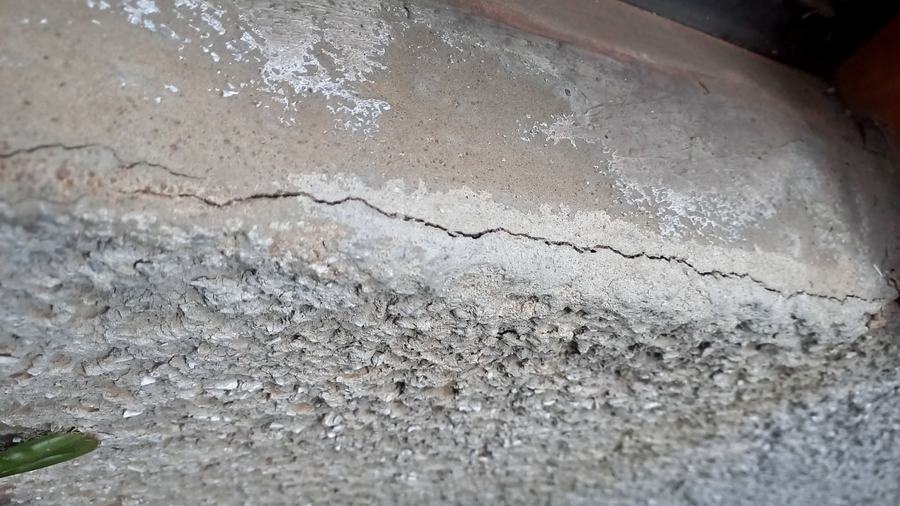 Fissura longitudinal acompanhada de eflorescência em superfície de concreto