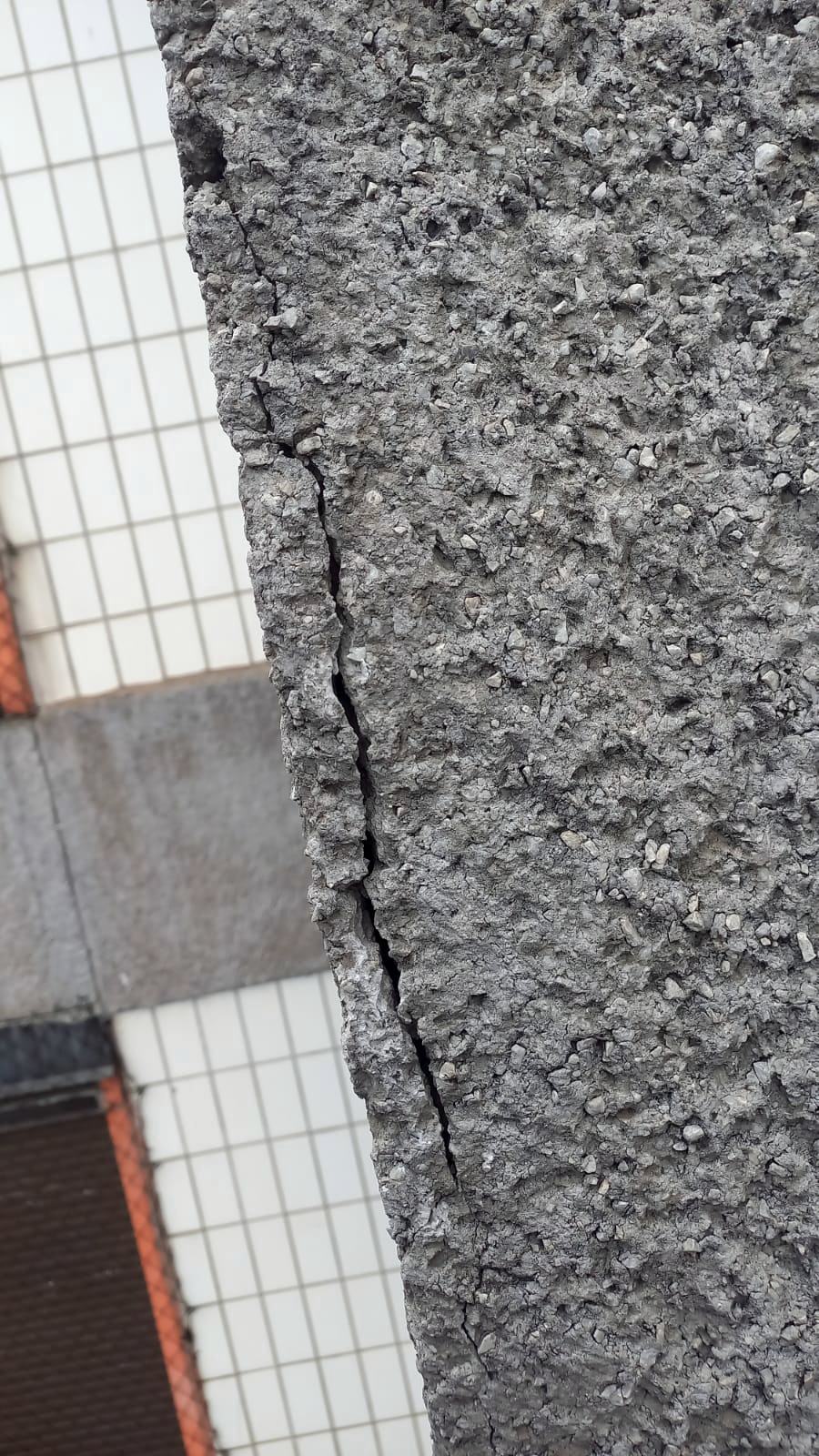 Fissura propagando entre revestimento em mosaico e substrato de concreto